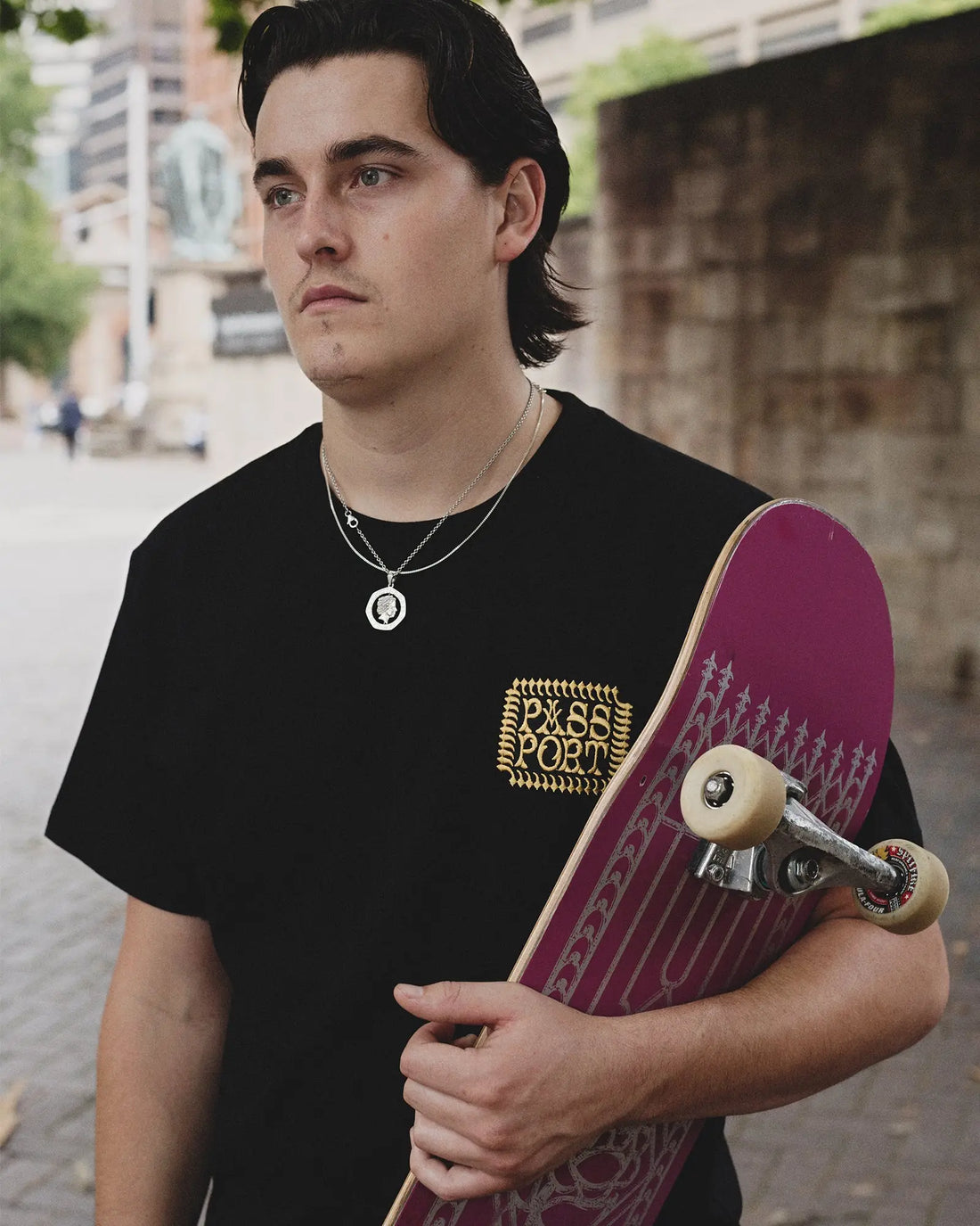 man in black tee shirt holding a skateboard